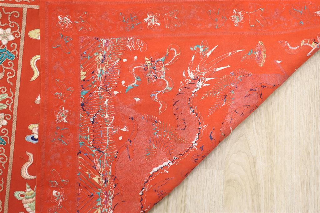 A early 20th century Chinese red felt square panel embroidered with a central motif of a dragon, width 86cm height 84cm